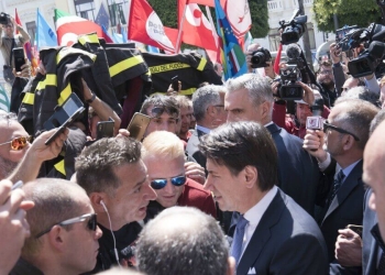 Il premier Giuseppe Conte con i Vigili del fuoco in protesta (LaPresse)