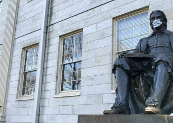 La statua di John Harvard con la mascherina anti-Coronavirus (Foto LaPresse)