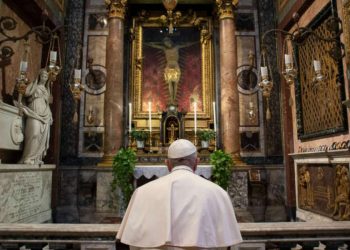 Papa Francesco prega in ginocchio davanti al crocifisso nella chiesa di San Marcello