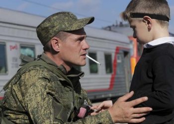 Soldato russo (o ucraino) saluta il figlio alla partenza per il fronte (LaPresse)