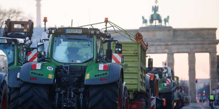 Trattori a Berlino, davanti alla Porta di Brandeburgo (Ansa)