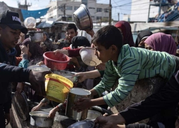 Palestinesi cercano di accaparrarsi un po' di cibo e acqua a Rafah (Ansa)