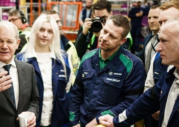 Olaf Scholz parla con alcuni dipendenti di uno stabilimento BMW (Ansa)