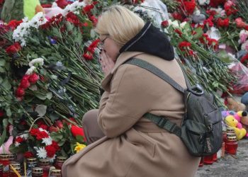 Donna in preghiera per le vittime dell'attentato alla Crocus City Hall (Ansa)