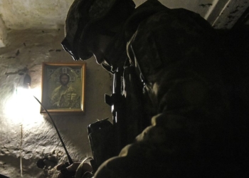 Soldato ucraino in una postazione radio nei pressi del fronte (Ansa)