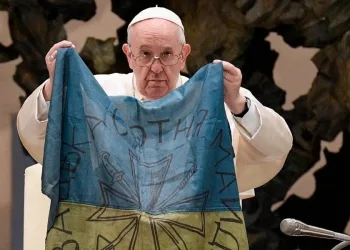 Papa Francesco nel 2022 con una bandiera dell'Ucraina proveniente da Bucha (Ansa)