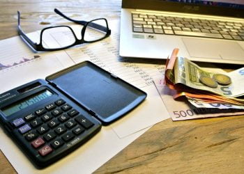 calcolatrice e banconote sul tavolo