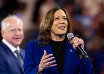 Kamala Harris, dietro di lei Tim Walz (Ansa)