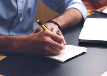 Uomo che scrive sulla scrivania