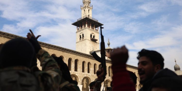 "Ribelli" di Hayat Tahrir al Sham a Damasco, nei pressi della Moschea degli Omayyadi (Ansa)