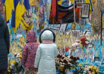 Vicino a un memoriale improvvisato per i militari ucraini caduti e i volontari internazionali, in Piazza dell'Indipendenza a Kiev (Ansa)