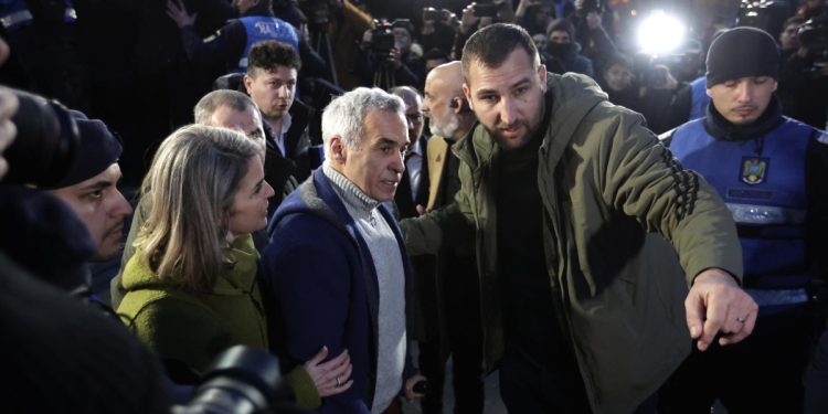 Calin Georgescu (c) mentre viene arrestato (Ansa)