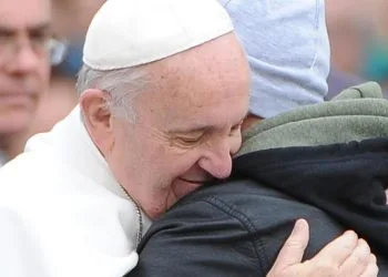 Papa Francesco abbraccia un uomo e sorride (Foto: ANSA - 2015)