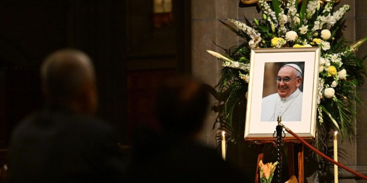 Fedeli in adorazione davanti ad una foto di Papa Francesco (ANSA/EPA)