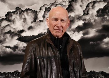 Sebastião Salgado davanti a una delle sue celebri fotografie. Presentazione di Amazonia, 2021 (Ansa)