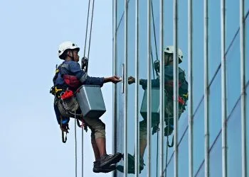 Operaio su tetto per lavare