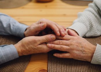 Mani anziani che si stringono