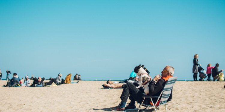 Anziano in spiaggia con il cane