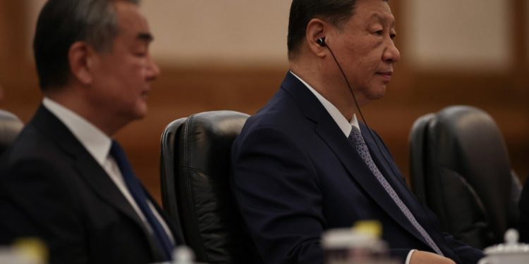 Il Presidente cinese Xi Jinping e il suo ministro degli Esteri Wang Yi (Ansa)