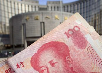 100 yuan renminbi. Sullo sfondo, la Popular Bank of China (Ansa)