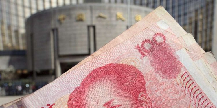 100 yuan renminbi. Sullo sfondo, la Popular Bank of China (Ansa)