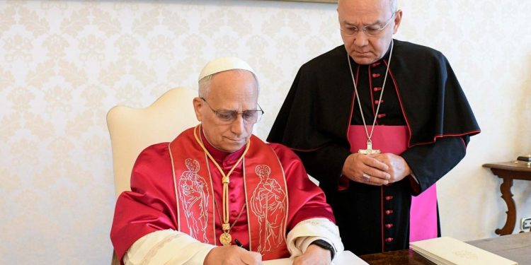 Papa Leone XIV mentre firma l'Esortazione apostolica "Dilexi Te" (Ansa)