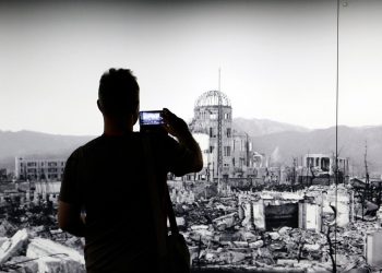 Al Peace Memorial Museum di Hiroshima un visitatore fotografa una gigantografia della città 80 anni prima. 5 agosto 2025 (Ansa)