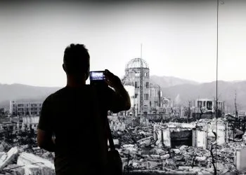 Al Peace Memorial Museum di Hiroshima un visitatore fotografa una gigantografia della città 80 anni prima. 5 agosto 2025 (Ansa)