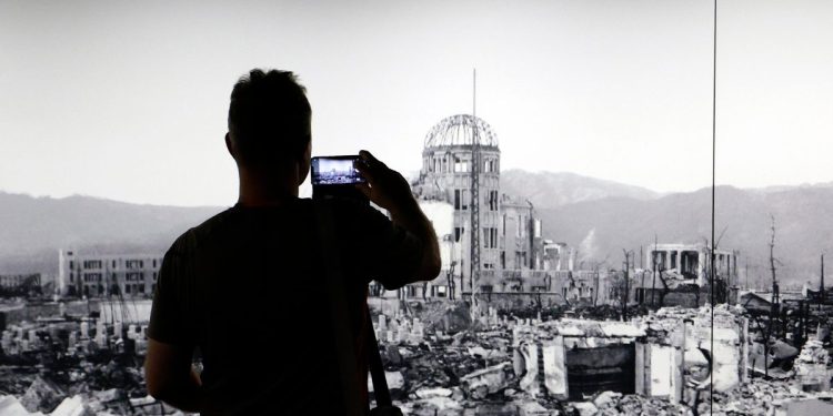 Al Peace Memorial Museum di Hiroshima un visitatore fotografa una gigantografia della città 80 anni prima. 5 agosto 2025 (Ansa)