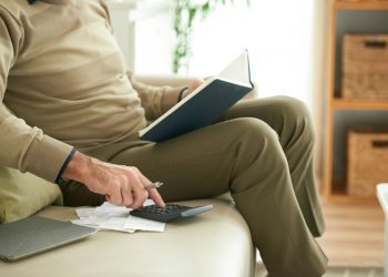 Anziano seduto a fare calcoli