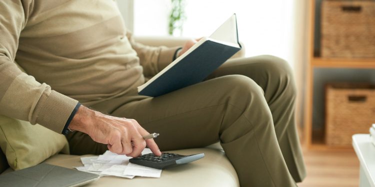 Anziano seduto a fare calcoli