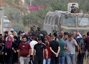 Soldati israeliani fermano i palestinesi sfollati dal campo profughi di Nur Shams mentre tentano di tornare al loro campo. presso Tulkarem (Ansa)